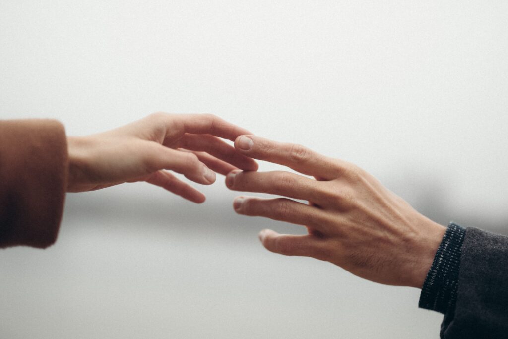 Two hands reaching out, symbolizing connection and intimacy.